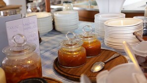 A buffet setup with jars of marmalade and a sign indicating available condiments. - Albatros Club Mykonos (Mykonos)
