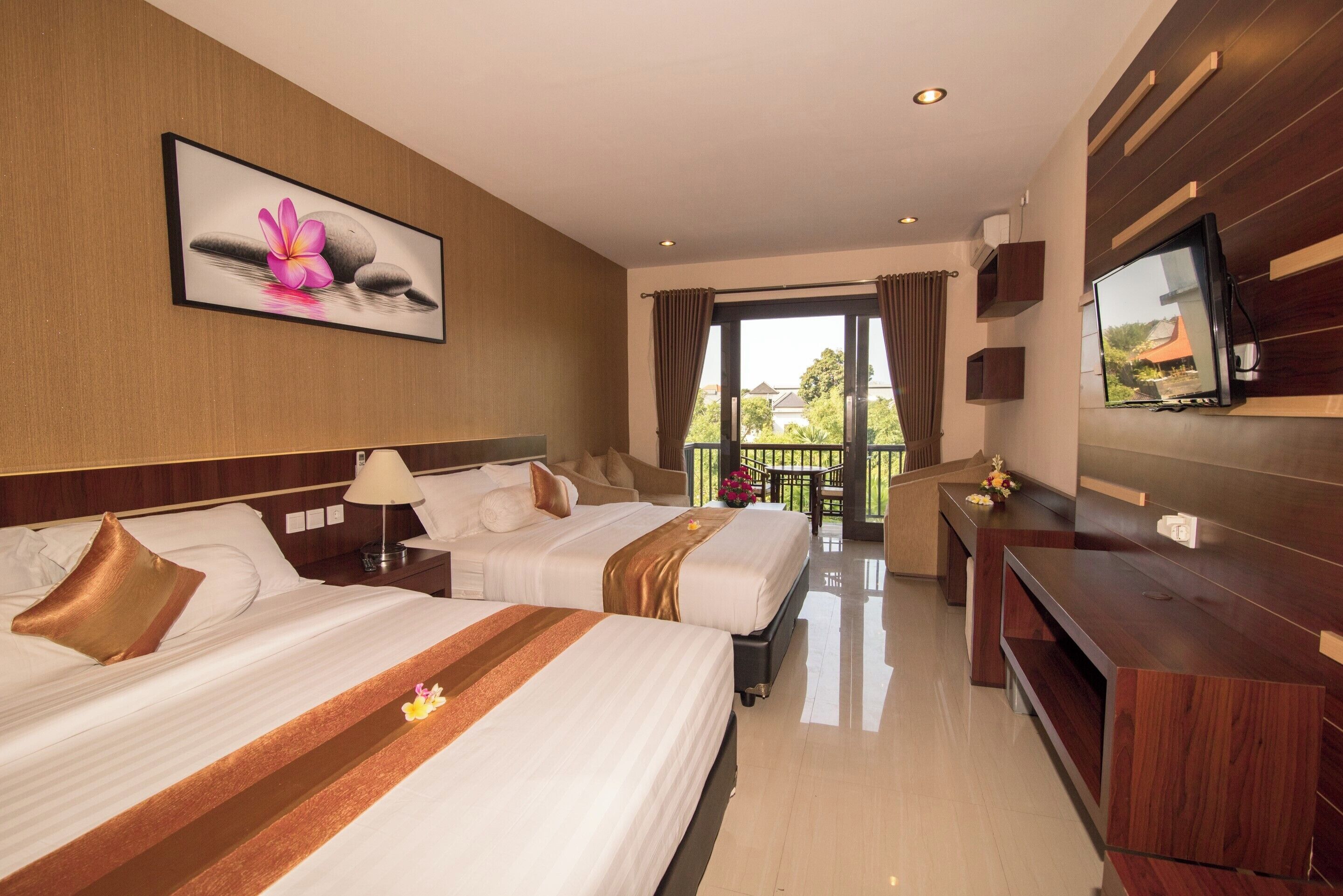 A hotel room with two beds, a TV, a desk, and a balcony with a view.
