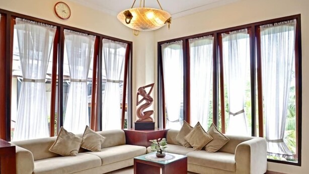 A living room with two sofas, a coffee table, and a decorative sculpture. - Puri Nusa Indah (Denpasar)