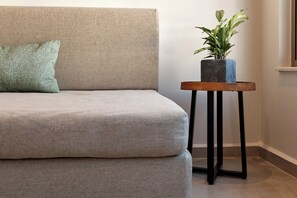 Ein Sofa mit Kissen und ein kleiner Tisch mit einer Pflanze daneben.