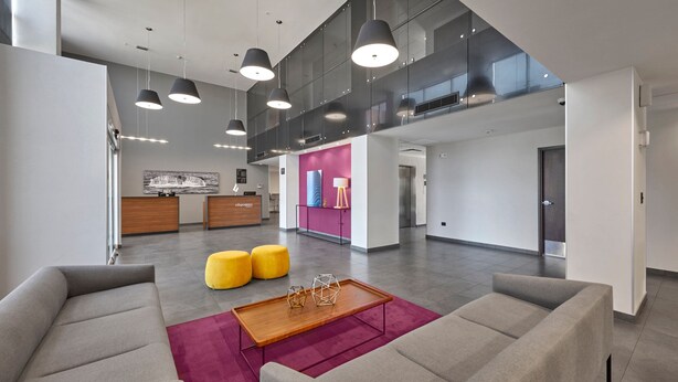 A spacious lobby with high ceilings, modern lighting, and a reception desk. - City Express by Marriott Tijuana Otay (Tijuana)