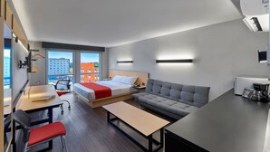 A modern hotel room with a bed, sofa, desk, and chair. - City Express by Marriott Tijuana Otay (Tijuana)