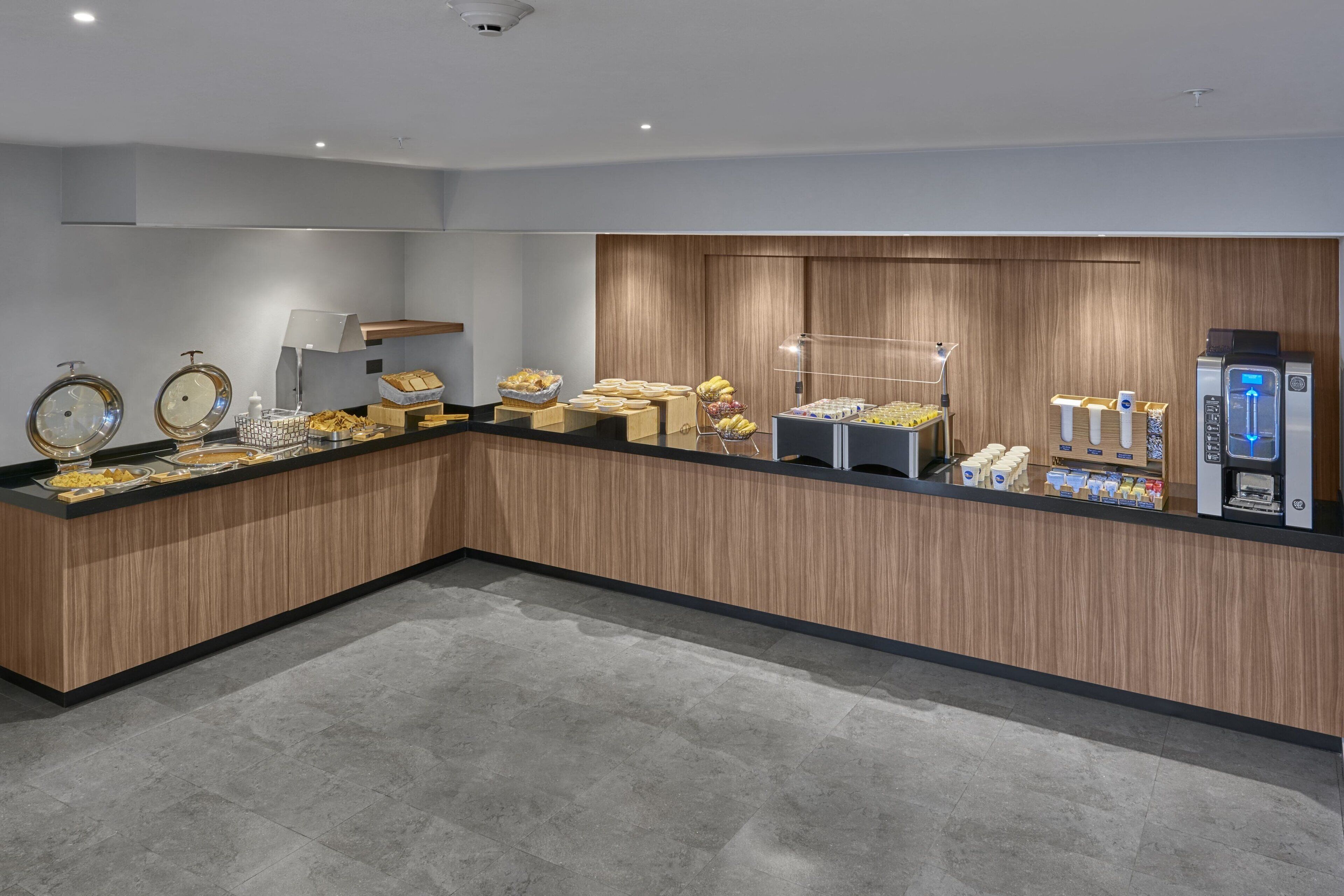 A modern breakfast bar with a variety of food items and a coffee machine.