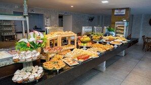 A buffet with various food items and a glass display case. - EL ARAM BEACH & CONVENTION (João Pessoa)