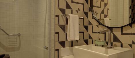 A modern bathroom with a shower, a sink, and a mirror.