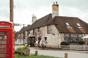 A traditional stone building with a sign for 'Five Bells Inn' and a red telephone booth. - The Five Bells Inn Brabourne (Ashford)