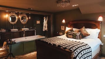 Una camera da letto con un letto grande, una toeletta con due specchi, un lampadario e un comodino con una lampada.