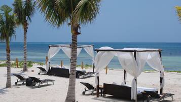 On the beach, white sand, sun loungers, beach umbrellas