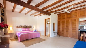A bedroom with a bed, wooden ceiling beams, a ceiling fan, and a wardrobe. - La Casa del Alux - Adults Only (Isla Holbox)