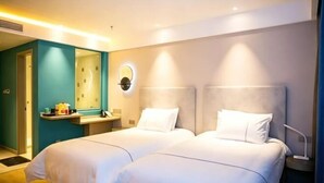 Une chambre d’hôtel avec deux lits, une salle de bain et un miroir.
