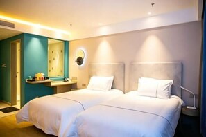Una habitación de hotel con dos camas, un baño y un espejo.