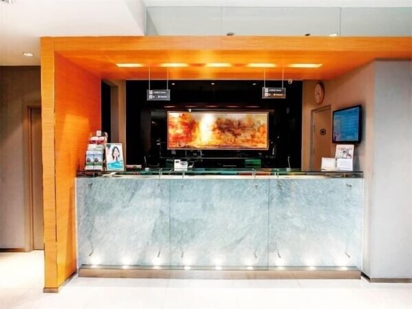 A reception area with a marble counter, a large flat-screen TV, and a clock on the wall. - Jinjiang Inn (Tumed Right Banner Salaqi Railway Station) (Baotou)