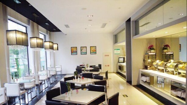A modern dining area with tables and chairs, a buffet counter, and a reception desk. - Jinjiang Inn Zhuji Datang Hotel (Shaoxing)