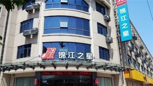 A building with a sign reading "锦江之星" and a large red logo. - Jinjiang Inn Zhuji Datang Hotel (Shaoxing)