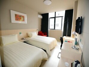 A hotel room with two beds, a desk with a chair, a TV, and a window with curtains. - Jinjiang Inn Zhuji Datang Hotel (Shaoxing)