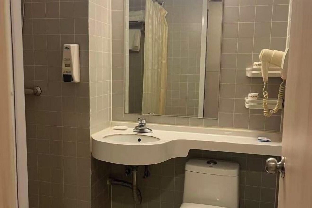 Ein Badezimmer mit Waschbecken, Spiegel, Handtuchhalter und Toilette.