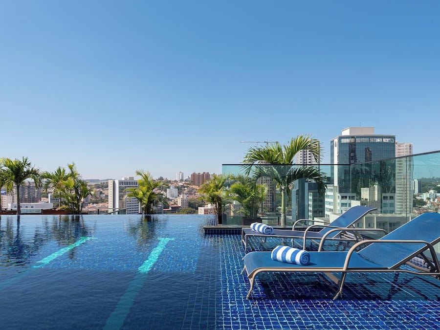 Una piscina al aire libre, sombrillas, tumbonas