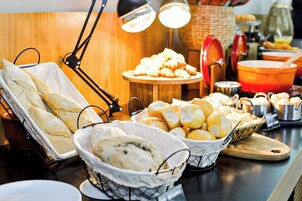 Un bufé con panes y pasteles varios.