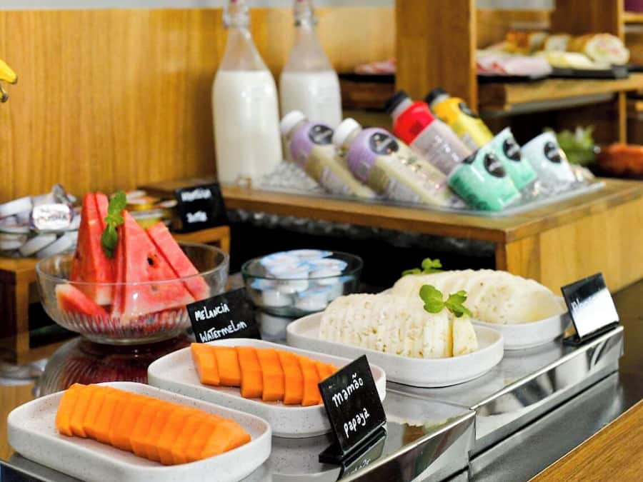 A buffet with various food items including watermelon, papaya, and rice.