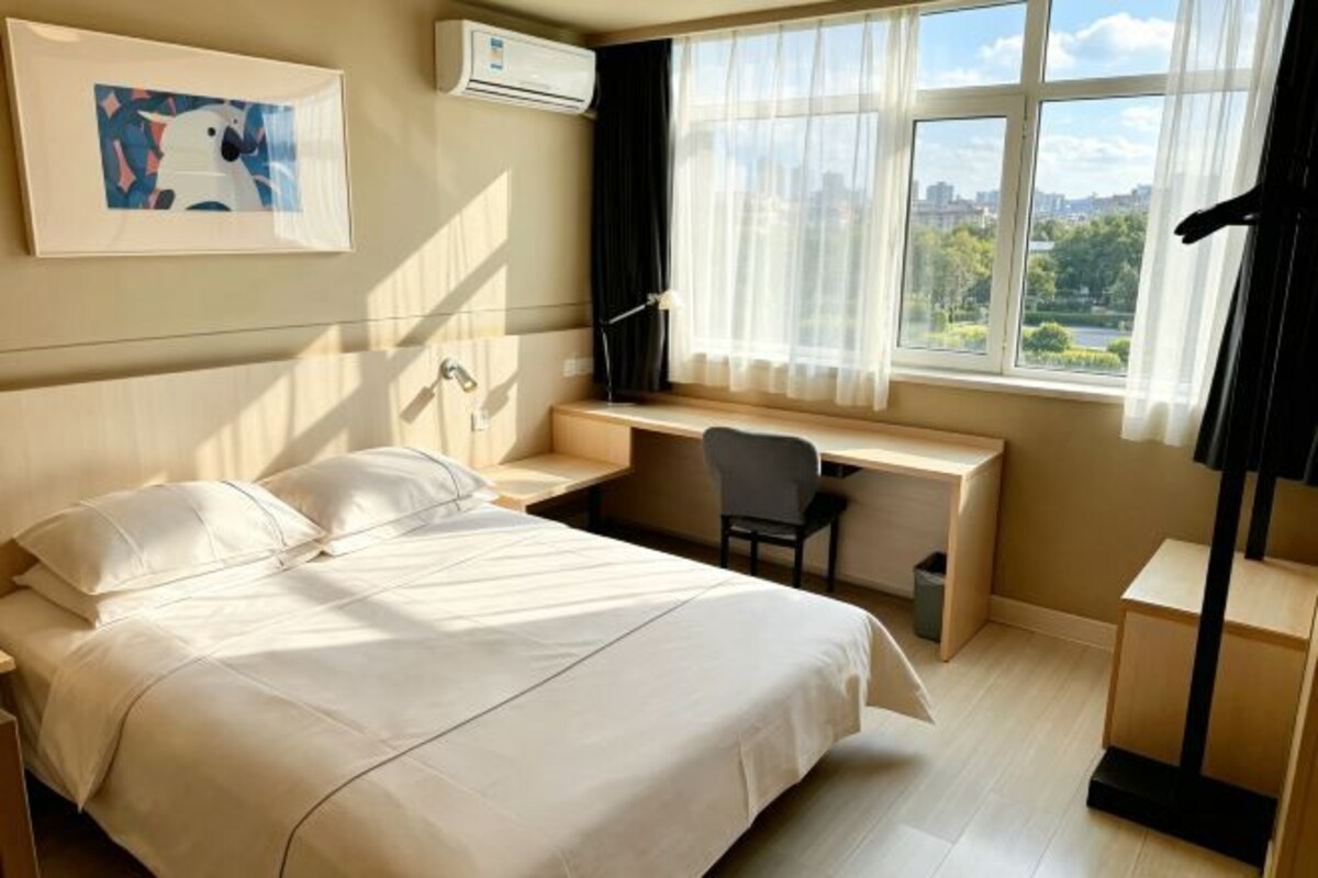 Una habitación de hotel con cama, escritorio, silla y ventana con vista.