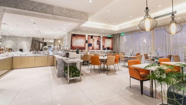 A modern hotel dining area with a central island, multiple tables, and chairs. - Jinjiang Inn Select (Wujiang Tongli Yunliqiao) (Suzhou)
