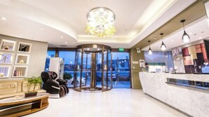 A hotel lobby with a reception desk, seating area, and a revolving door. - Jinjiang Inn Select (Wujiang Tongli Yunliqiao) (Suzhou)