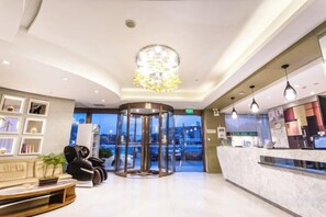 A hotel lobby with a reception desk, seating area, and a revolving door. - Jinjiang Inn Select (Wujiang Tongli Yunliqiao) (Suzhou)