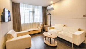 A modern hotel room with a sofa, armchair, and a small round table. - Jinjiang Inn Select (Wujiang Tongli Yunliqiao) (Suzhou)