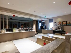 A modern restaurant with a long counter, multiple seating areas, and a decorative wall piece.