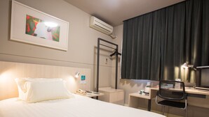 A hotel room with a bed, a desk, a chair, a desk lamp, a telephone, and a framed picture on the wall. - Jinjiang Inn Select (Fanchang RT-Mart Business Square) (Wuhu)
