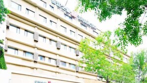 A multi-story hotel with a flat facade, multiple balconies, and a row of shops on the ground floor. - Jinjiang Hotel (Tianjin West Station Xianyang Road Subway Station) (Tianjin)