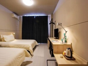 A hotel room with two beds, a desk with a computer, a lamp, and a kettle. - Jinjiang Inn (Harbin Shida Night Market Hexinglu Road Metro Station ) (Harbin)