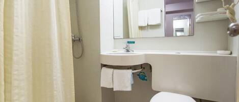 Un baño con inodoro, lavamanos y ducha.