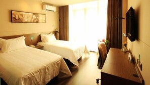 A hotel room with two beds, a desk, a chair, a flat-screen TV, and a painting on the wall. - Jinjiang Inn Select Huangshan Shixi County Huizhou Old Town (Huangshan)