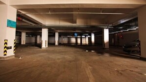 An underground parking garage with multiple levels, concrete pillars, and a few parked cars. - Jinjiang Inn Select Huangshan Shixi County Huizhou Old Town (Huangshan)