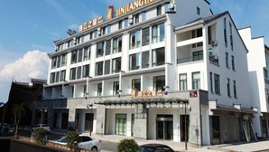 A multi-story hotel with a modern design, featuring a prominent signage for "ININGINN" and a visible entrance with a glass door. - Jinjiang Inn Select Huangshan Shixi County Huizhou Old Town (Huangshan)