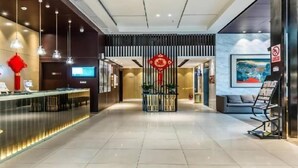 A modern hotel lobby with a reception desk, a seating area, and a large painting on the wall. - Jinjiang Inn Select (Hangzhou Binjiang University Town Puyan Metro Station) (Hangzhou)