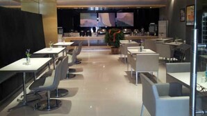 A modern restaurant with a long counter, multiple tables, and chairs. - Jinjiang Inn Tianjin Wuqing Development Zone (Tianjin)