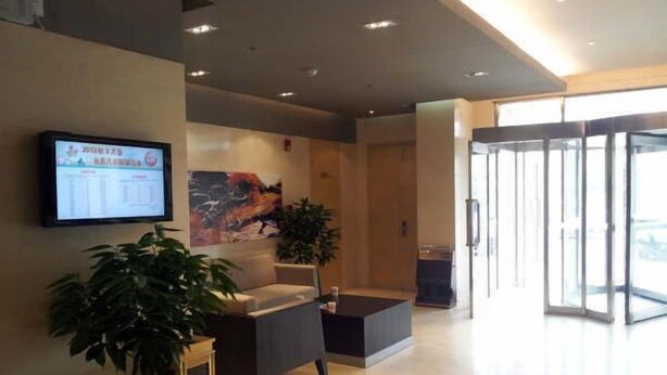 A modern lobby with a reception desk, seating area, and a large digital display. - Jinjiang Inn Tianjin Wuqing Development Zone (Tianjin)