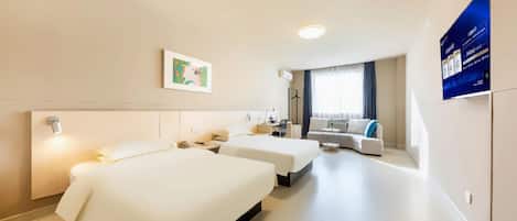 Une chambre d’hôtel avec deux lits, un bureau, une chaise, un canapé et une fenêtre avec des rideaux.