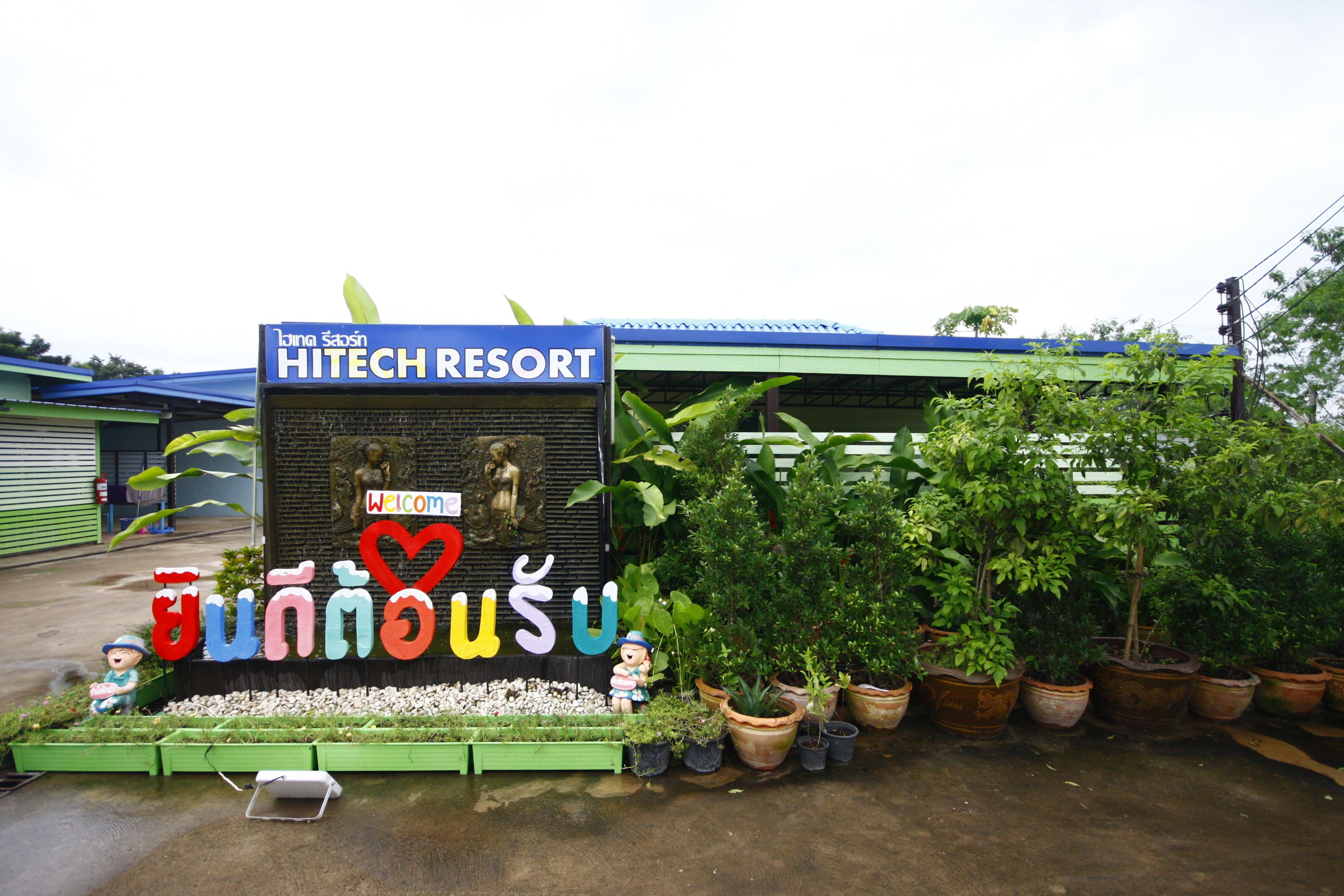A sign for HITECH RESORT with a welcome message and Thai characters.