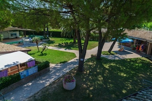 Ein Innenhof mit Pool, Sitzbereichen und einem kleinen Gebäude mit einem Ziegeldach.