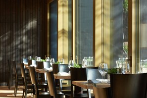 A restaurant with wooden tables and chairs, arranged for dining.
