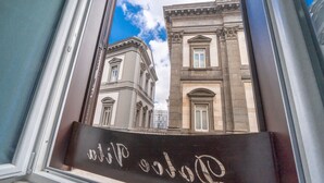 A view through a window of a building with classical architecture, including columns and arched windows. - B&B DolceVita Napoli (Naples)