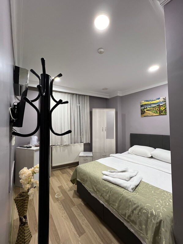 Un dormitorio moderno con cama, armario, espejo y perchero.