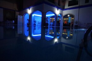 A modern building with a reflective pool, arched openings, and blue lighting. - Hotel Zelis (Asilah)