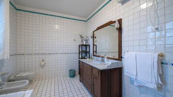 Un baño con inodoro, lavamanos y espejo.