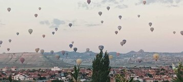A town with numerous hot air balloons in the sky.