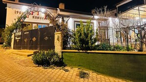 Un edificio con un letrero que dice “İPEN KONUKHANE” y una entrada con puerta de reja.