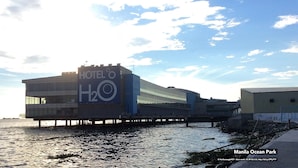 Un hotel con un letrero grande que dice "HOTEL o H2O" en una propiedad frente al mar.